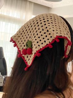 a woman wearing a crocheted hat with cherries on it