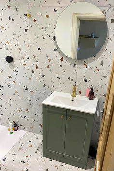 Bathroom with White Terrazzo Tiles on the wall and floor with an Olive coloured Unit Sink with Gold Accents and a Cirlce Mirror Above. Wall Patterns, Kitchen Style, Tile Design, Wall Tiles