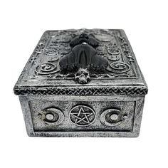 an ornate metal box with a skull and pentagramus on the front, surrounded by filigrees