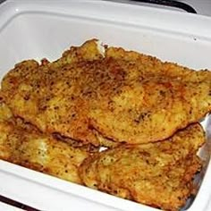 two pieces of fried chicken in a white container