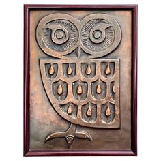 an owl is sitting on top of a metal plaque