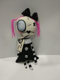 a doll with pink hair wearing a black and white dress