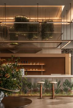 the inside of a restaurant with tables and plants on the counter top, along with hanging planters