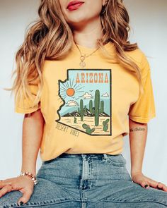 PLEASE NOTE, DUE TO THE BUSY HOLIDAY SEASON ANY ORDERS PLACED AFTER 12/09/24 ARE NOT GUARANTEED TO ARRIVE BY CHRISTMAS.Looking for a unique way to show your love for Arizona? Look no further than our Retro Comfort Colors Arizona Desert Vibes shirt! This unique and vintage style graphic tee would make the perfect girls' trip t-shirt! Comes in multiple colors! Check out more designs here: www.etsy.com/shop/jadeandroseshop ✨️SIZE AND FIT: Your shirt will be printed on a high-quality, soft and comfo Trendy Yellow Shirt With Screen Print, Cute Relaxed Fit Shirt With Letter Print, Trendy Yellow Shirt With Funny Print, Cute Yellow Shirt With Graphic Print, Yellow Shirt With Funny Print And Relaxed Fit, Yellow Shirt With Funny Print In Relaxed Fit, Cute Yellow Top With Screen Print, Cute Relaxed Fit Printed Shirt, Cute Yellow Shirt With Letter Print