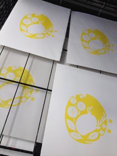 four yellow and white paper cut outs sitting on top of each other in front of a wire rack