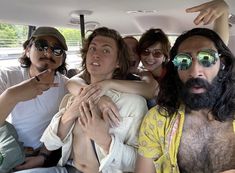 a group of people sitting in the back of a car with one person holding his arm up