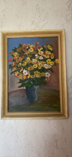 an oil painting of yellow and white flowers in a blue vase on a beige wall