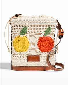 a crocheted bag with an orange, yellow and green flower on the front