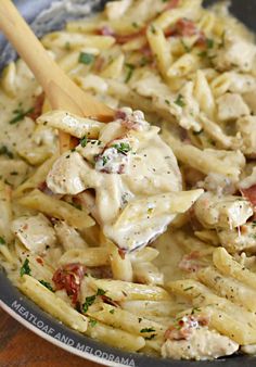 chicken bacon ranch pasta in a skillet with a wooden spoon on the side and text overlay that reads, chicken bacon ranch pasta one pan 30 minute dinner