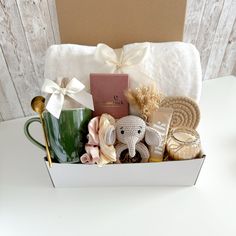 a gift box filled with items such as a coffee mug, cookies and other things