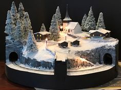 a model of a snow covered town with trees and buildings on it's sides