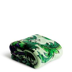 the green and purple blanket is folded on top of each other, with an intricate design