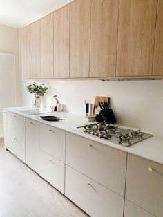 a kitchen with white counter tops and wooden cabinets