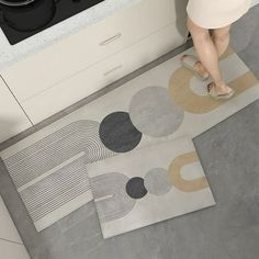 a woman is standing on the kitchen floor with her feet up in front of an oven