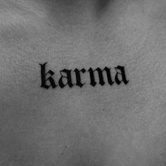 the word karma written in cursive ink on a man's back chest