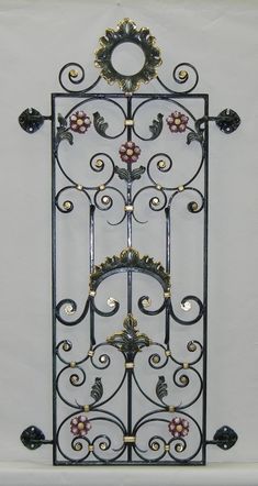 an ornate metal rack with candles on it's sides and flowers in the middle