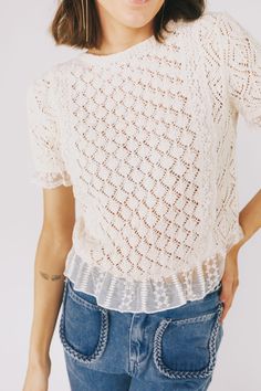 This vintage ivory top is a must-have with its crochet design, ruffle hem, and elegant mesh netting adorned with a delicate floral pattern and eyelets. Perfect for a stylish look that will turn heads. Details Crochet top Ruffle hem (mesh with eyelets) Short sleeves Mesh net with floral pattern and eyelets at sleeves, up the chest & back, and at hem Loose knit Ivory color Sizing Approximate measurements: SIZE LENGTH BUST Small 22" 36" Medium 22.5" 38" Large 23" 39" Fabric has some stretchModel is Eyelet Shorts, Mesh Netting, Ivory Tops, Crochet Design, Loose Knit, Top Sales, Ivory Color, Need You, Crochet Designs