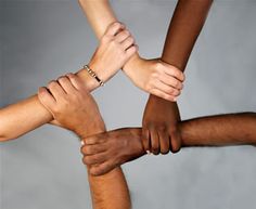 several people are holding hands together in a circle with their hands on top of each other