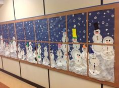 a bulletin board with snowmen on it in the middle of an office building's hallway