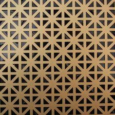 a close up view of a metal surface with geometric designs in gold and black colors