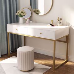 a white desk with a gold frame and round mirror on the wall next to it