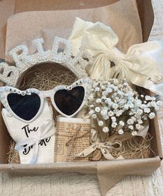 a box filled with lots of different items like sunglasses and some hair clips on top of it