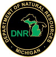 the department of natural resources michigan logo on a black and gold circle with green letters