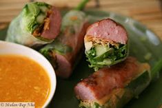 some food is on a green plate next to a bowl of soup and chopsticks