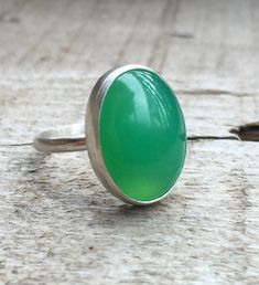 This bright green chrysoprase has been set in sterling silver with a handmade ring band from sterling silver half dome wire. This ring is simple and elegant. The lovely bright green chrysoprase is 18mm x 13mm in size. Made to order! Handmade Green Oval Cabochon Ring, Handmade Green Emerald Oval Cabochon Ring, Handmade Green Chrysoprase Ring, Handmade Green Rings For Everyday Wear, Handmade Green Rings For Everyday, Chrysoprase Emerald Ring With Oval Cabochon For Gift, Green Oval Chalcedony Rings, Green Chalcedony Gemstone Rings, Oval Green Chalcedony Rings