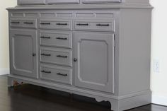 a large gray dresser sitting on top of a hard wood floor