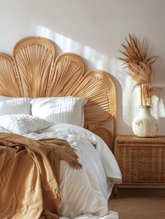 a bed with white sheets and pillows in a bedroom next to a wicker headboard