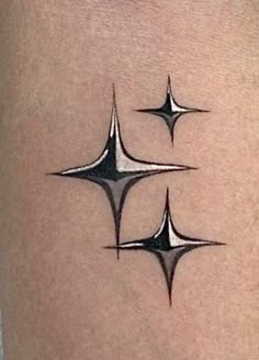 three black and white tattoos on the back of a woman's thigh, each with different shapes