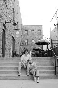 black and white photograph of two people sitting on steps