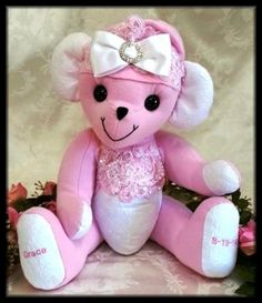 a pink teddy bear with a white bow on its head sitting in front of flowers