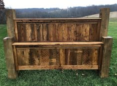 a wooden bench sitting on top of a lush green field