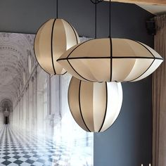 three lamps hanging from the ceiling in a room with checkered flooring and chandelier