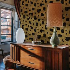 a living room with a table and two vases on top of it next to a window