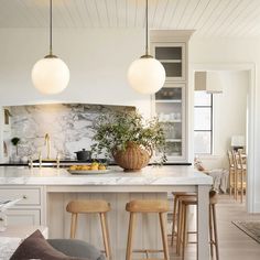 a kitchen with marble counter tops and wooden stools