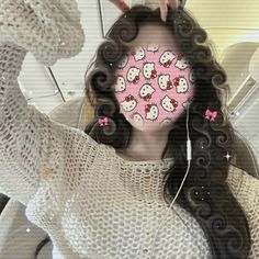 a woman holding her hair in front of her face with hello kitty stickers on it