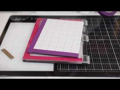 the cutting board is being used to cut out paper and other crafting supplies for making notebooks