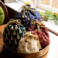 three small pouch bags sitting on top of a wooden table