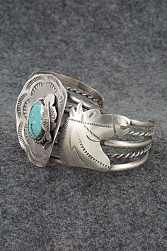 This amazing turquoise and sterling silver bracelet featuring horses and a hat a with feather in the brim was made by Navajo silversmith Tim Yazzie. The back is signed T Yazzie and stamped sterling.Size: 5 5/8" (will fit up to a 6 7/8" wrist)Gap: 1 1/4"Width: 1 5/8"Free shipping on all orders! We ship with USPS and always include tracking. All orders ship within a day of payment.Returns are accepted up to 30 days after you receive your order. Just send us a message. Our shop offers cash back or Horse Jewelry, American Jewelry, Sterling Silver Bracelet, Native American Jewelry, Turquoise Sterling Silver, Sterling Silver Bracelets, Native American, Silver Bracelet, Turquoise