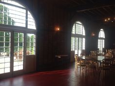 an empty dining room with large arched windows