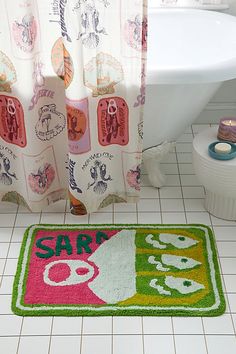 a bathroom with a rug that says sary on the floor next to a bathtub