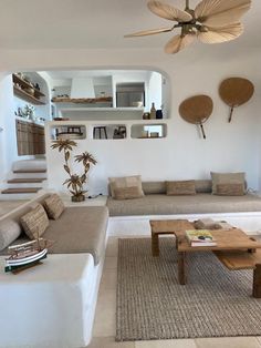 a living room filled with furniture and a ceiling fan