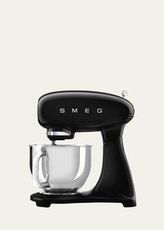 the smego coffee maker is black and has a glass cup on it's side