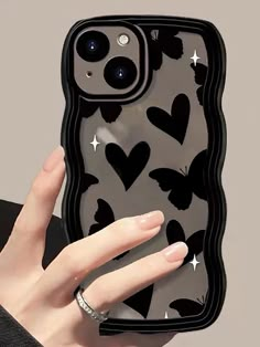 a woman holding up her phone case with hearts on the front and stars on the back