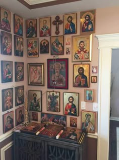 a room filled with pictures and paintings on the wall next to a table in front of a doorway