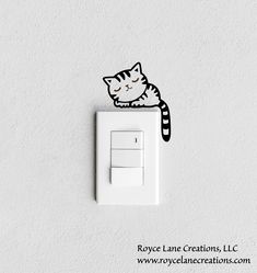 a white light switch with a cat sticker on it