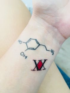 a woman's wrist tattoo with the letter x on it